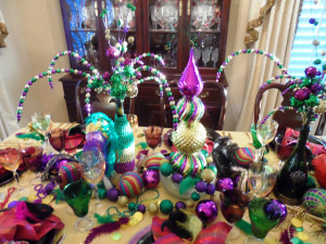 DIY Mardi Gras Centerpiece with green, purple, and gold beads bulbs and ornaments.